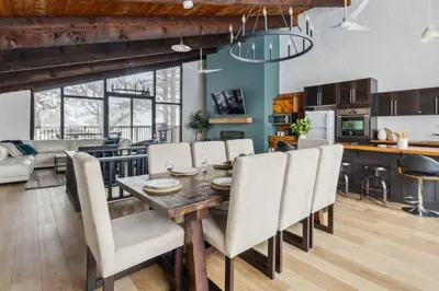a kitchen and dining room with a wooden table and chairs at 8 Bedroom Blue Mountain Chalet with Ping-Pong - 218 Arlberg in Blue Mountains