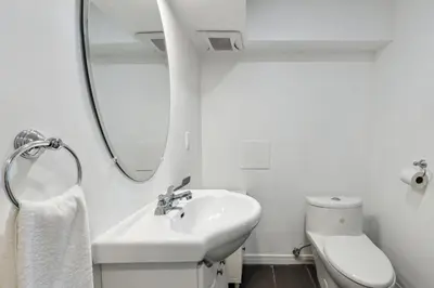 a white bathroom with a sink and a mirror at 8 Bedroom Blue Mountain Chalet with Ping-Pong - 218 Arlberg in Blue Mountains