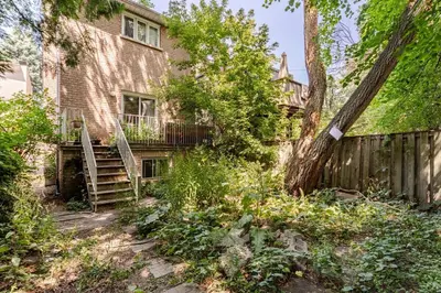 a house with a wooden fence and a tree at Studio Apartment in Casa, semi-bsmt in Toronto