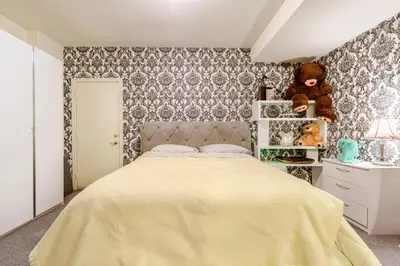 a bedroom with a large bed and a teddy bear at Studio Apartment in Casa, semi-bsmt in Toronto