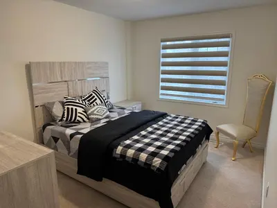 a bedroom with a bed and a window and a chair at Fully furnished 3BR, 3WR entire two storey with unfinished basement- Ford Milton , ON Canada in Milton