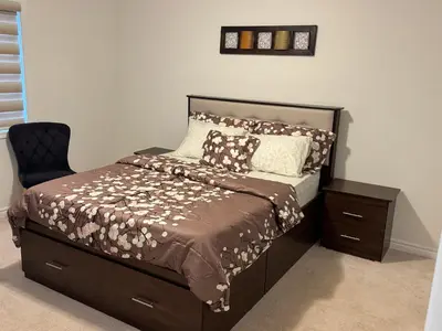 a bedroom with a bed with a chair and a bed sidx sidx sidx at Fully furnished 3BR, 3WR entire two storey with unfinished basement- Ford Milton , ON Canada in Milton