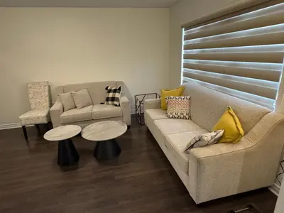 a living room with two couches and a table at Fully furnished 3BR, 3WR entire two storey with unfinished basement- Ford Milton , ON Canada in Milton