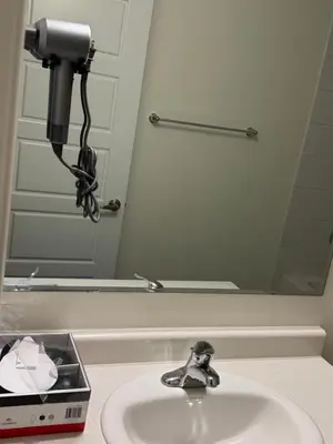 a bathroom sink with a camera and a mirror at Fully furnished 3BR, 3WR entire two storey with unfinished basement- Ford Milton , ON Canada in Milton