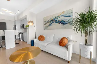 a living room with a white couch and a table at Hidden gem in Humber bay shores Toronto with parking in Toronto