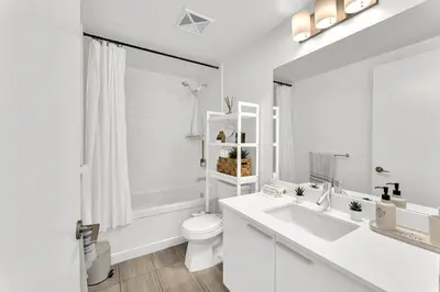 a white bathroom with a toilet and a sink at Hidden gem in Humber bay shores Toronto with parking in Toronto
