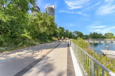 a bridge over a river with people walking on it at Hidden gem in Humber bay shores Toronto with parking in Toronto