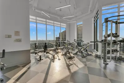 a gym with treadmills and ellipticals in a room with windows at Hidden gem in Humber bay shores Toronto with parking in Toronto