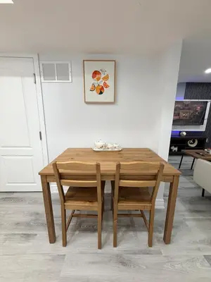 a wooden table and chairs in a room at Modern Cozy Basement Suite Free Parking in Brampton