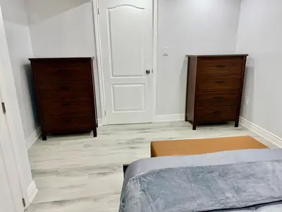 a bedroom with two dressers and a bed at Modern Cozy Basement Suite Free Parking in Brampton