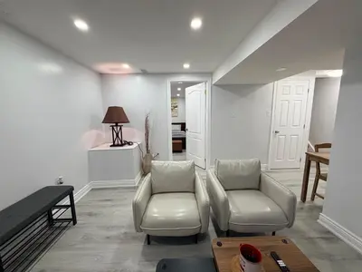 a living room with two chairs and a table at Modern Cozy Basement Suite Free Parking in Brampton