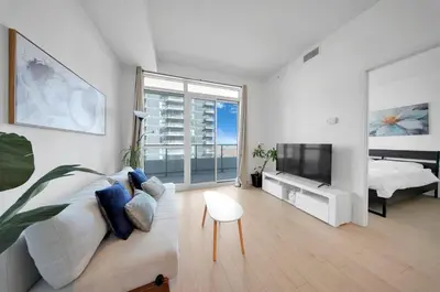 a living room with a couch and a tv at Tranquil Lakeside Suite Toronto in Toronto