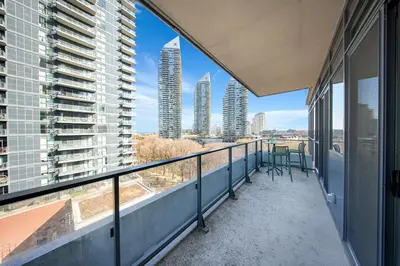 a balcony with chairs and a view of skyscrapers at Tranquil Lakeside Suite Toronto in Toronto