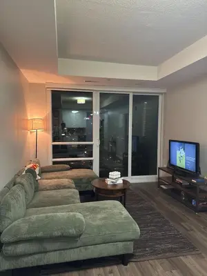 a living room with a couch and a television at One-Bedroom Apartment with Den With Amazing Views of Hamilton in Hamilton