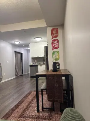 a living room with a table and a kitchen at One-Bedroom Apartment with Den With Amazing Views of Hamilton in Hamilton