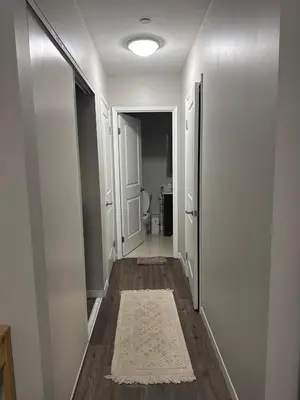 an empty hallway with a door and a rug at One-Bedroom Apartment with Den With Amazing Views of Hamilton in Hamilton