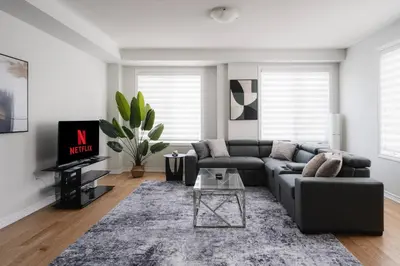 a living room with a couch and a table at Airport/Family/3bdrm/5beds/4bath/Workspace/Hiking in Brampton
