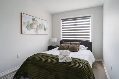 a bedroom with a bed with two towels on it at Airport/Family/3bdrm/5beds/4bath/Workspace/Hiking in Brampton