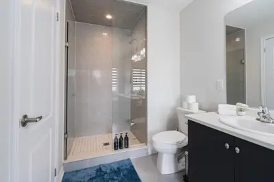 a bathroom with a shower and a toilet and a sink at Airport/Family/3bdrm/5beds/4bath/Workspace/Hiking in Brampton