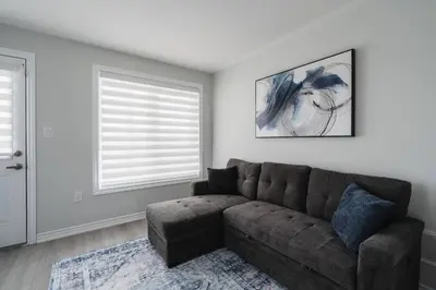 a living room with a couch and a window at Airport/Family/3bdrm/5beds/4bath/Workspace/Hiking in Brampton