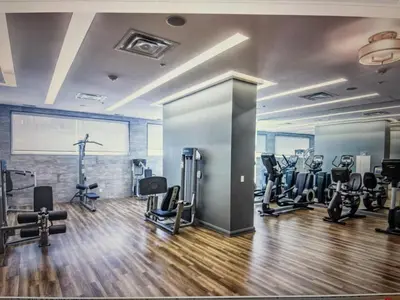 a gym with several treadmills and exercise bikes at Elegant and Charm Superior Suite Yorkville Toronto in Toronto