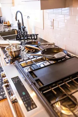 a kitchen counter with a stove with pans on it at Relaxing Spa Getaway, Sauna, Hot Tub & Heated Pool in Blue Mountains