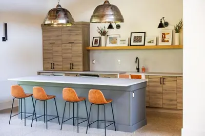 a kitchen with a large island with orange bar stools at Relaxing Spa Getaway, Sauna, Hot Tub & Heated Pool in Blue Mountains