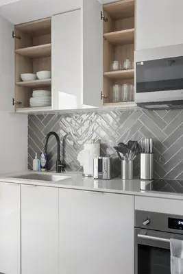a white kitchen with a sink and a microwave at Stylish 2BR Retreat Parking & Sleeps 6 in Toronto