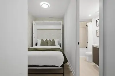 a bedroom with a large bed and a bathroom at Stylish 2BR Retreat Parking & Sleeps 6 in Toronto