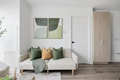 a living room with a white couch and green pillows at Elegant 2BR Condo with 55 TV & City Views in Toronto
