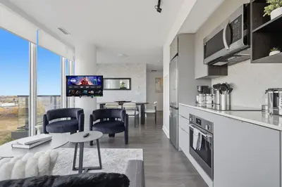 a kitchen and living room with a table and chairs at Modern 3BR Condo Sleeps 8 with Floor-to-Ceiling Views in Toronto
