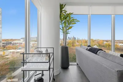 a living room with a couch and a large window at Modern 3BR Condo Sleeps 8 with Floor-to-Ceiling Views in Toronto