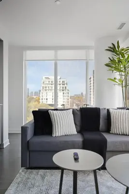 a living room with a couch and a large window at Modern 3BR Condo Sleeps 8 with Floor-to-Ceiling Views in Toronto