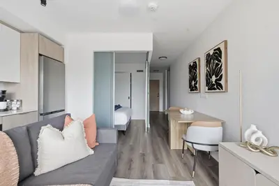 a living room with a couch and a desk at Cozy 2BR Condo with Free Parking & City Views in Toronto