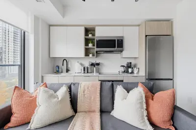 a living room with a gray couch with pillows at Cozy 2BR Condo with Free Parking & City Views in Toronto