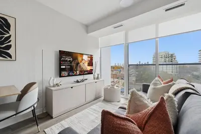 a living room with a couch and a tv at Cozy 2BR Condo with Free Parking & City Views in Toronto