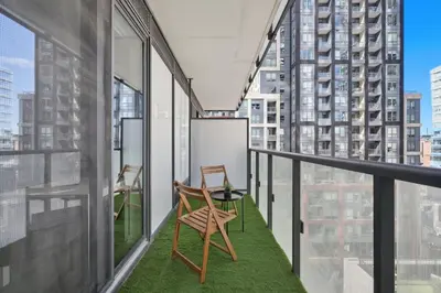 two chairs on a balcony with a view of a city at Chic Downtown TO Studio Near Entertainment Dist in Toronto