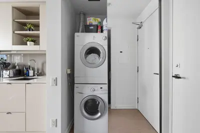a laundry room with a washer and dryer in it at Chic Downtown TO Studio Near Entertainment Dist in Toronto
