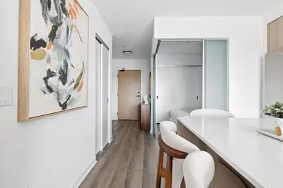 a white room with a table and chairs at Modern West Getaway 2BR Condo with Free Parking in Toronto