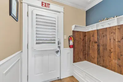 a bathroom with an exit sign next to a white door at The Sweet Spot - Walk to Village & Hot Tub in Blue Mountains