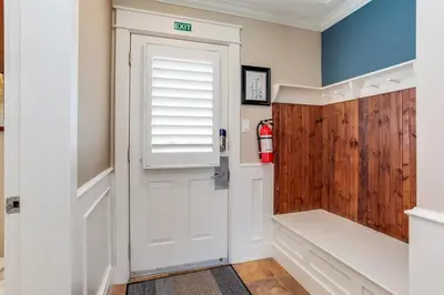 a bathroom with a white door and a wooden wall at The Sweet Spot - Walk to Village & Hot Tub in Blue Mountains