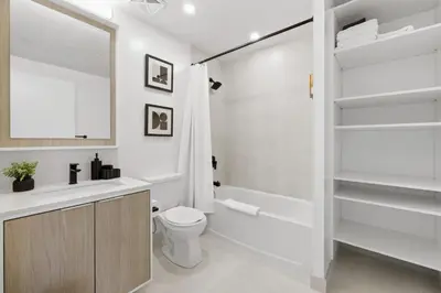 a bathroom with a toilet and a tub and a sink at Skyline Studio with Stunning City Views & Parking in Toronto