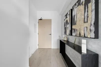 a living room with a large painting on the wall at Skyline Studio with Stunning City Views & Parking in Toronto