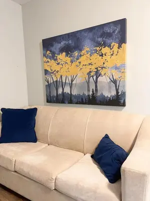 a couch in a living room with a painting on the wall at Cottage getaway in the city, for intimate family gathering in Ajax