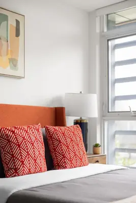 a bed with red and white pillows and a window at Modern 4BR Home Sleeps 12 Steps to CN Tower in Toronto