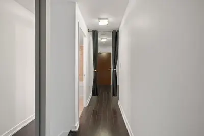 a hallway with white walls and a brown door at Modern 4BR Home Sleeps 12 Steps to CN Tower in Toronto
