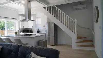 a kitchen and a living room with a kitchen and stairs at Water View - Modern Cottage in Niagara-on-the-Lake in Niagara on the Lake