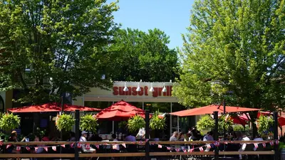 people sitting at tables with umbrellas in front of a restaurant at Water View - Modern Cottage in Niagara-on-the-Lake in Niagara on the Lake
