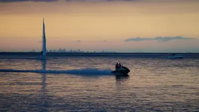 a group of people on a boat in the water with a sailboat at Water View - Modern Cottage in Niagara-on-the-Lake in Niagara on the Lake
