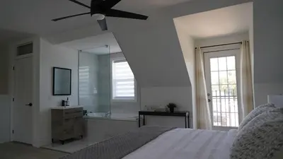 a bedroom with a bed and a sink and a mirror at Water View - Modern Cottage in Niagara-on-the-Lake in Niagara on the Lake